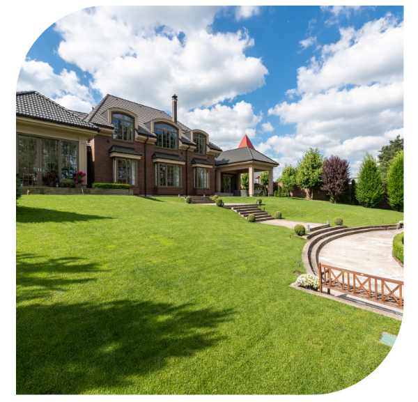 A large house surrounded by a well-maintained lawn and a vibrant garden, showcasing a serene outdoor environment.