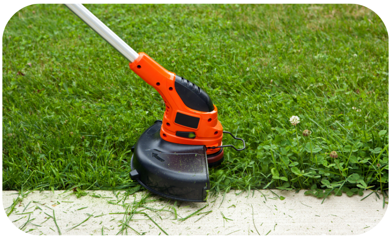 A person operates a lawn mower, efficiently cutting the grass in a well-maintained yard.